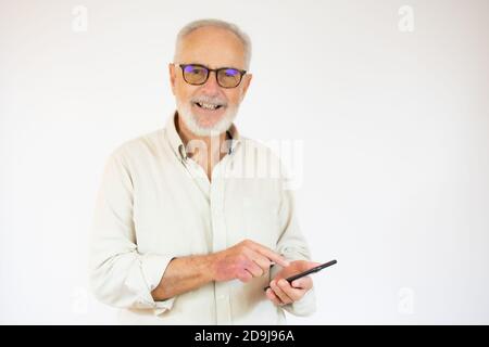Studio di felice anziano sopportato uomo d'affari sorridente mentre usando telefono cellulare con occhiali su sfondo bianco Foto Stock