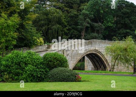 Antico ponte in pietra del XIV secolo sul fiume Coquet a Warkworth, Northumberland, Regno Unito Foto Stock