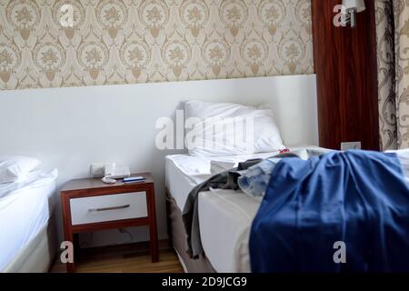 Le cose sono sparse casualmente sul letto dell'hotel Foto Stock