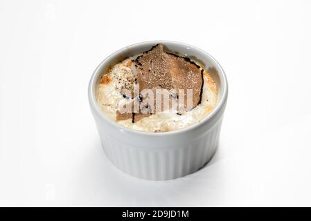 Uova al forno e fonduta di formaggio Fontina con tartufo affettato in cocotte, isolato su bianco Foto Stock