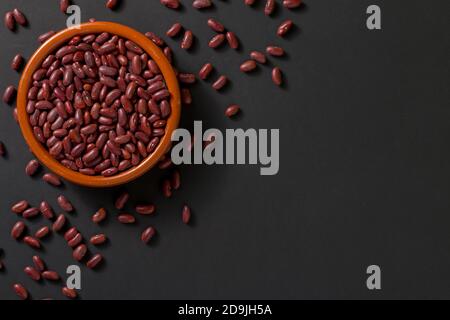 Vista dall'alto di una ciotola con fagioli rossi su sfondo nero. Foto Stock