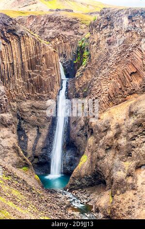 Litlanesfoss è una bellissima piccola cascata in Islanda. È scolpita nella roccia basaltica e situato sul fiume Hengifossa vicino al suo più grande br Foto Stock