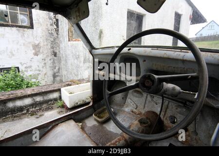 Barrhill, Ayrshire, Scozia, Regno Unito. Arrugginita auto d'epoca abbandonata, spogliata di interni Foto Stock