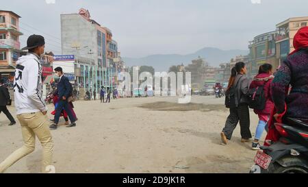 Kathmandu, Nepal - 11/29/2019: Persone con maschere di protezione dal forte inquinamento atmosferico camminando su una strada sporca nel centro di Kathmandu. Foto Stock