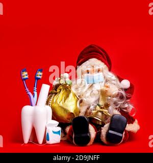 Merry Christmas Card da Dentist Tooth Model con regali su sfondo rosso con Copy Space. Foto Stock