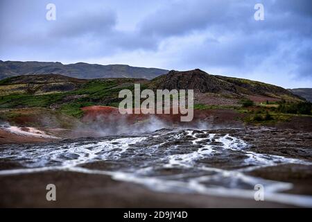 Turisti a valle geotermica Haukadalur in attesa del Grande Geysir o Strokkur geysir di eruttare. Geysir è uno dei turisti più popolari Foto Stock