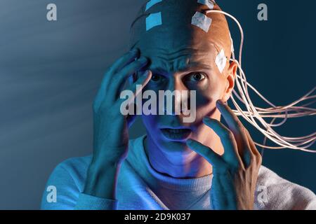 Uomo con elettrodi in testa urla nell'orrore, un polygraph Lie detector test, memoria Erasure. Foto Stock
