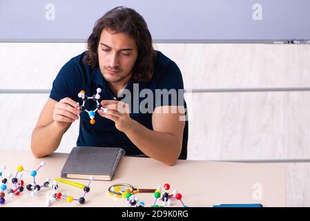 Giovane scienziato seduto in classe Foto Stock