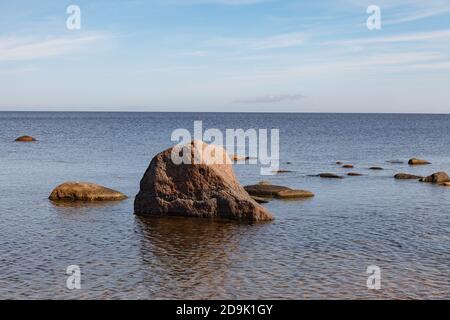 Pietre di granito sulla spiaggia del Golfo di Finlandia in una giornata estiva brillante Foto Stock