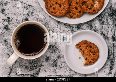 Biscotti marroni, una tazza di caffè nero e un stuzzicante di dolci fatti in casa. Prima colazione, pausa caffè. Cibo dolce. Vista dall'alto, disposizione piatta Foto Stock