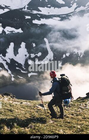 Viaggiatore uomo escursioni da solo in montagna avventura attiva stile di vita viaggiare estate vacanze all'aperto solitudine armonia con escursionista natura in piedi cl Foto Stock
