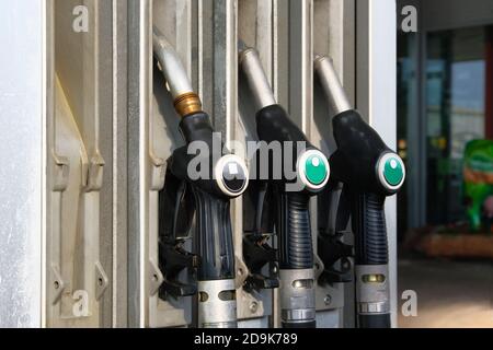 Concetto di benzina e di prodotti a benzina. Pistole del carburante nere sulla stazione di rifornimento. Pompaggio della benzina alla pompa benzina Foto Stock