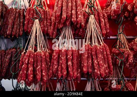 Commercio di strada a Chinatown. Salsicce cinesi rosse affumicate. Foto Stock