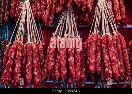 Commercio di strada a Chinatown. Salsicce cinesi rosse affumicate. Foto Stock