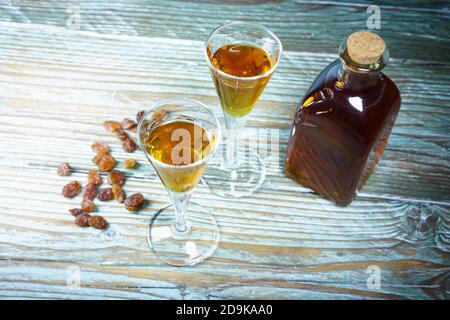 Primo piano di bicchieri di cognac, bottiglia e uva passa Foto Stock