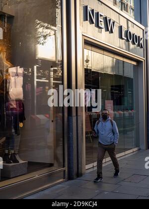 NUOVO LOOK: Una persona che indossa una maschera passa un negozio New Look su Oxford Street chiuso il primo sabato di Lockdown 2. Foto Stock