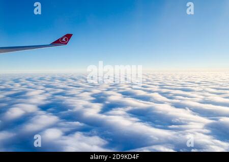Logo Turkish Airlines sull'ala destra. Vista dalla finestra dell'aeromobile. Orizzonte Blu sopra le nuvole nell'Oceano Atlantico. Viaggio da Istanbul a New York Foto Stock