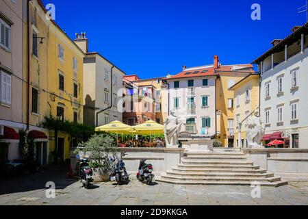 Pirano, Istria, Slovenia - vista sulla città nel centro storico, qui la piazza del 1 maggio, la gente nei vicoli della città vecchia del porto di Pirano sul Mar Mediterraneo. Foto Stock