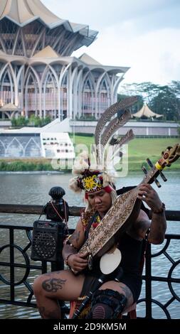 Sarawakian Man suonando Sape, tradizionale strumento musicale Sarawak Foto Stock