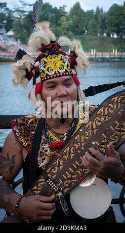 Sarawakian Man suonando Sape, tradizionale strumento musicale Sarawak Foto Stock