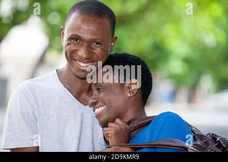 giovane coppia in piedi abbracciata, sorridente. Foto Stock