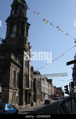 Ayr, Ayrshire, Scozia, Vista da New Bridgegate Street guardando la Sandgate con Ayr municipio a sinistra. Gli stragges di Bunting hanno attraversato la strada per il Burns Festival Foto Stock