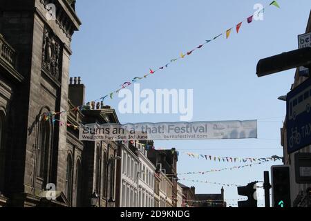 Ayr, Ayrshire, Scozia, Vista da New Bridgegate Street guardando la Sandgate con Ayr municipio a sinistra. Gli stragges di Bunting hanno attraversato la strada per il Burns Festival Foto Stock