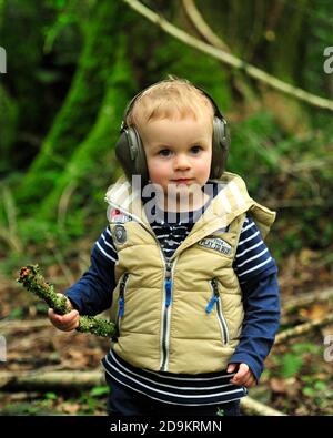 bambino piccolo che indossa cuffie protettive durante un tiro di gioco Foto Stock