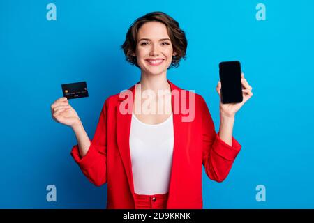 Ritratto di bella signora allegra che dimostra il dispositivo di pagamento della carta di credito trasferimento del metodo di passaggio isolato su sfondo di colore blu brillante Foto Stock