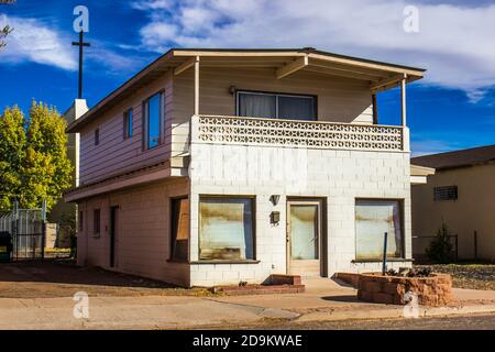 Abbandonata Two Story Block Home nel retro della Chiesa con Croce Foto Stock