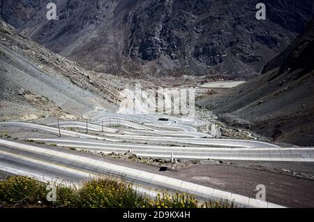 Strada serpentina Caracoles Juncal, vicino valle di Río Juncalillo. Strada di montagna curvilinea con molte curve che scendono. Vicino al confine tra Cile e Argentina Foto Stock