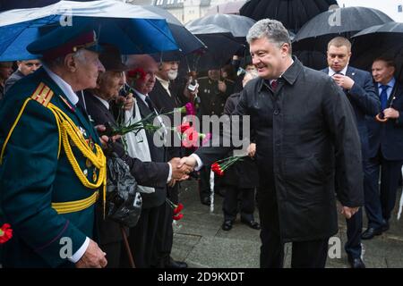 KIEV, UCRAINA - 22 giu 2015: Presidente dell'Ucraina Petro Poroshenko, scuote le mani con i veterani nel Parco della Gloria a Kiev Foto Stock