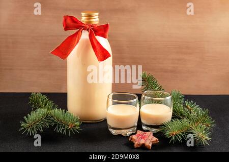 Eggnog fatto in casa in bottiglia e due bicchieri con biscotti di Natale Foto Stock