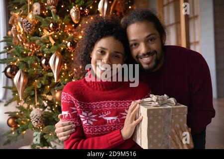 Foto ritratto di testa sorridente coppia afroamericana con regalo di Natale Foto Stock
