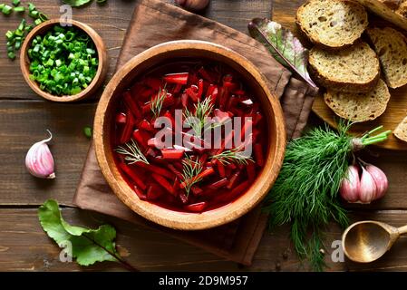 Zuppa di barbabietole, borscht in ciotola su fondo di legno. Vista dall'alto, disposizione piatta Foto Stock