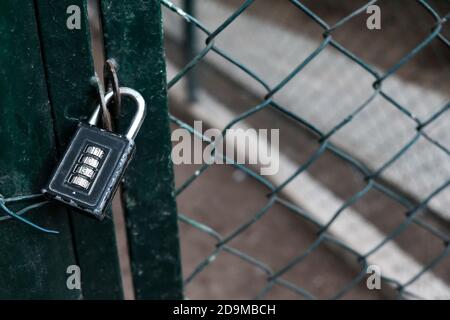 Ingresso chiuso con lucchetto su recinzione metallica. Area riservata con accesso vietato. Posto protetto su blocco durante la quarantena Foto Stock