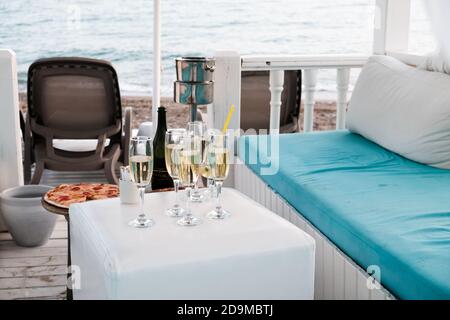 Belek, Turchia - Ottobre 2020: Lounge VIP di lusso per i ricchi turisti sulla spiaggia vicino al Mar Mediterraneo. Champagne e pizza vicino ai lettini, mare nella parte posteriore Foto Stock