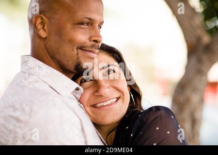 La coppia multiracial Late Forties si è abbracciata sul marciapiede di San Diego Foto Stock