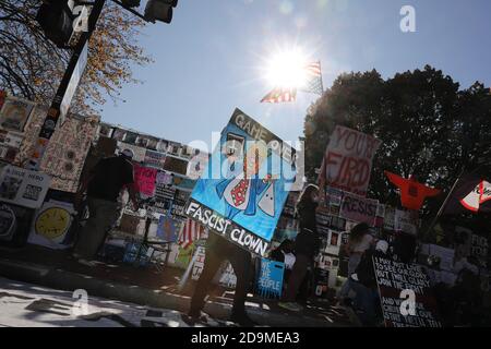 Washington, Stati Uniti. 06 novembre 2020. I manifestanti contro il presidente Donald Trump lanciano bandiere e si siedono davanti ai segnali che dicono 'Game over fascist Clown' 'You're Fired' 'resist' 'Remove Trump' si riuniscono al Black Lives Matter Plaza di fronte alla Casa Bianca mentre attendono il risultato delle elezioni presidenziali americane tra il presidente Donald Trump E l'ex Vice Presidente Joe Biden il 6 novembre 2020 a Washington. (Foto di Oliver Contreras/SIPA USA) Credit: Sipa USA/Alamy Live News Foto Stock