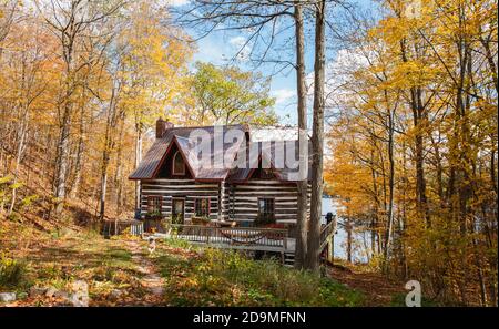 Cottage di capanna di ceppo nei boschi in Ontario, Canada in un giorno di autunno. Foto Stock