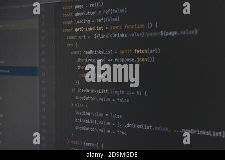 Il codice JavaScript del programma sullo schermo nero del computer. Il concetto di sito web, internet, sicurezza informatica, hacking e software. Foto Stock