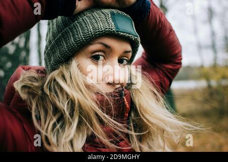 primo piano ritratto di donna in piedi nella foresta con il vento soffia Foto Stock