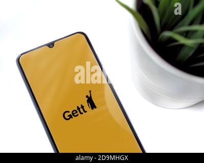 LOD, Israele - 8 luglio 2020: Spazio di lavoro moderno e minimalista con smartphone nero con schermo di lancio dell'app Gett con logo su sfondo bianco. Foto Stock