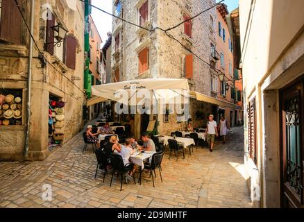 Rovigno, Istria, Croazia - gente nella caffetteria di strada nelle strade della città vecchia della città portuale di Rovigno. Foto Stock