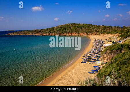 Isola di Andros, Cicladi, Grecia - lettini e ombrelloni sulla spiaggia di sabbia dorata nella parte occidentale dell'isola tra Gavrion e Batsi. Foto Stock