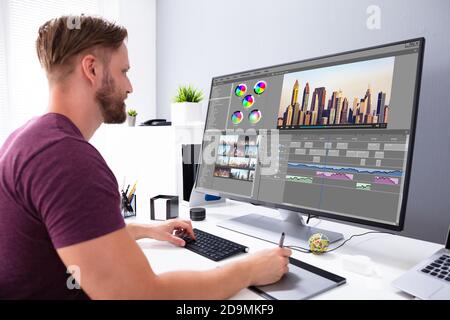 Editor video o Designer che utilizzano il software di editing Tech sul computer Foto Stock