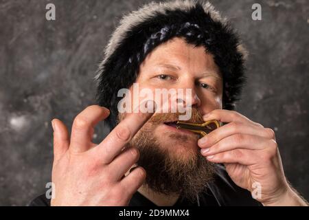 Uomo maturo in pelliccia cappello che gioca ebrei arpa ritratto studio Foto Stock