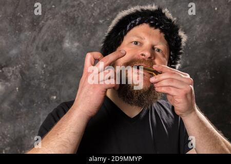 Uomo maturo in pelliccia cappello che gioca ebrei arpa ritratto studio Foto Stock