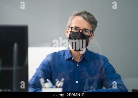 Receptionist in maschera presso il Medical Center Covid Office Foto Stock