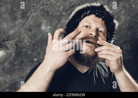 Uomo maturo in pelliccia cappello che gioca ebrei arpa ritratto studio Foto Stock